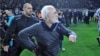 Russian-born Greek businessman and owner of PAOK Salonika, Ivan Savvides (center) takes the field , pictured with what appears to be a gun in his holster during his soccer team's game with rivals AEK Athens on March 11. 