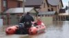 A woman and her pet are evacuated from a flooded street ride in the Russian city of Orenburg earlier this week. 