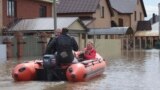 A woman and her pet are evacuated from a flooded street ride in the Russian city of Orenburg earlier this week. 