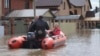 A woman and her pet are evacuated from a flooded street ride in the Russian city of Orenburg earlier this week. 