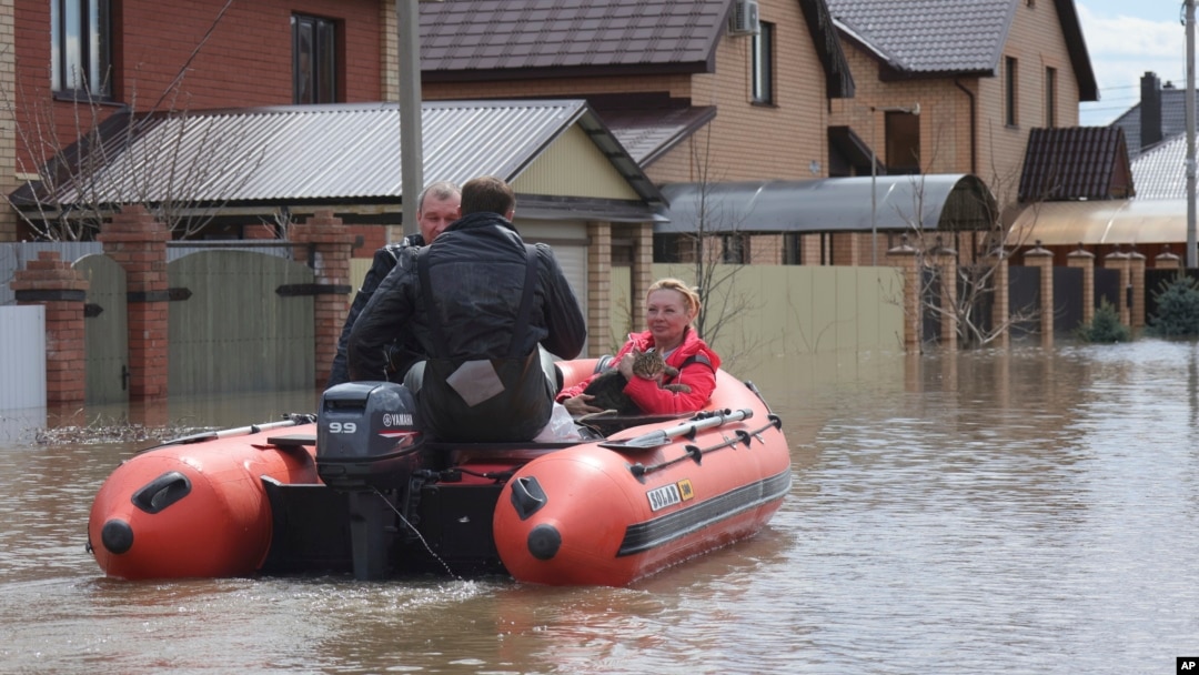 A woman and her pet are evacuated from a flooded street ride in the Russian city of Orenburg earlier this week. 