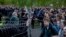 Demonstrators (right) stand outside a fence blocked by police as they protest plans to construct a church in a park in Yekaterinburg on May 14.
