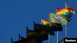 Steaguri LGBT și ale unor cluburi sportive pe un stadion din Seattle, în iunie 2019. Steagurile sunt arborate în acest fel an de an la toate meciurile, pe tot parcursul „lunii Pride”.
