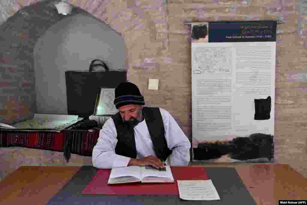 A museum worker reads a book in front of censored photographs of living things displayed at the Citadel of Alexander in Herat on January 7.The Koran does not forbid images of living things, but some hadiths -- ancient texts believed to document the actions, characteristics, and customs of the Prophet Muhammad -- indicate the founder of Islam opposed the representation of living things.