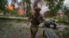 Полицай тича пред горяща къща, разрушена от руски въздушен удар във Вовчанск, Украйна, в събота, 11 май 2024 г. 