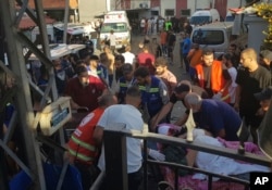 Lucrători ai Protecției Civile transportă un bărbat care a fost rănit după ce pagerul său a explodat, în sudul orașului port Sidon din Liban, pe 17 septembrie 2024.