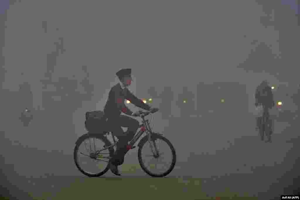 A boy rides his bike to school amid heavy smog in Lahore, Pakistan. (AFP/Arif Ali)