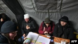 Oamenii se adăpostesc în centrele organizate de autorități unde-și pot alimenta gadgeturile la generatoare și unde pot bea un ceai cald.