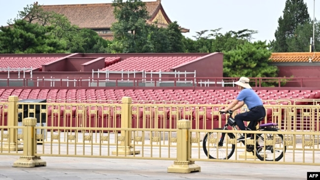 Một người đàn ông đạp xe trước khán đài được dựng lên tại Quảng trường Thiên An Môn cho cuộc duyệt binh vào ngày 3 tháng 9 để kỷ niệm 80 năm chiến thắng Nhật Bản và kết thúc Thế chiến thứ II.
