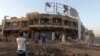 Iraqi men inspect the site of a car bomb explosion that killed at least seven people and wounded dozens in the neighborhood of Ur in eastern Baghdad late on September 22.