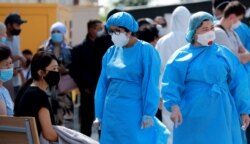 Қорғаныш киім киген медицина қызметкерлері.