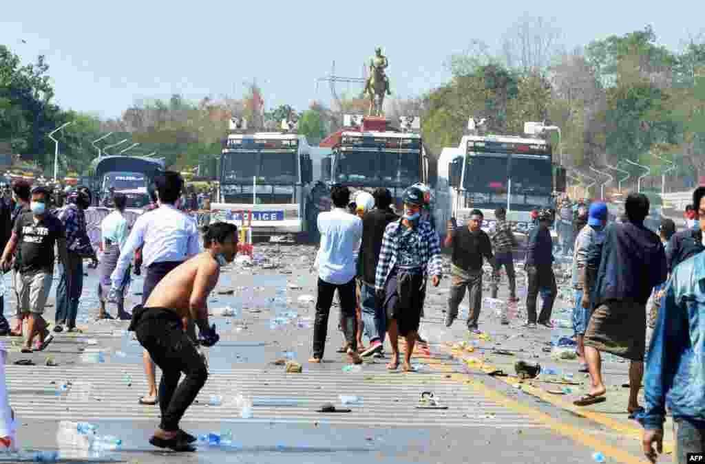 Demonstranti se suočavaju sa policijskim vozilima nakon što su ispaljivali vodene topove tokom demonstracija protiv vojnog puča 1. februara na spomeniku generalu Aung San (C), pokojnom ocu pritvorene vođe Mjanmara Aung San Suu Kyi u glavnom gradu Naypyidawu, 9. februara 2021. ( Foto STR / AFP)