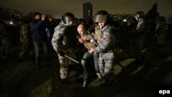 Russian policemen detaining someone near the Biryuza shopping mall in the Biryulyovo Zapadnoye District of Moscow on 13 October.