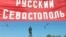 Ukraine -- A man passes near a placard reading "Russian Sevastopol" in the center city of Sevastopol, 26Sep2007