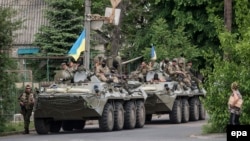 Ukrainian soldiers ride in an armored personal carrier near the town of Volnovakha, site of the deadliest attack on central troops so far in the separatism-fueled conflict.