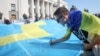Люди написали побажання на великому кримськотатарською прапорі, який запустять в Крим до Дня кримськотатарського прапора. Київ, 15 червня, 2021 року