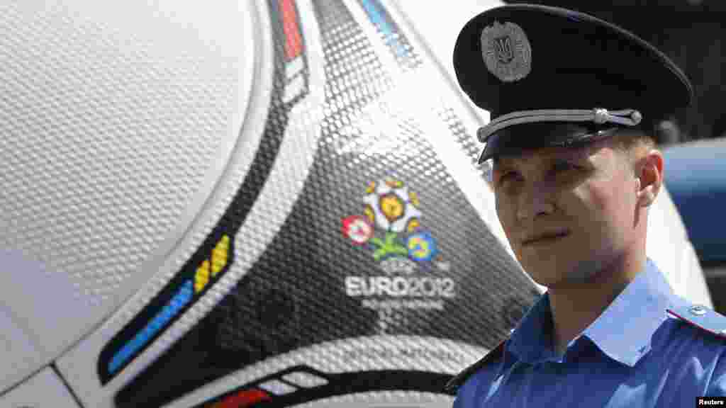 Ukraine -- A policeman patrols the street in front of a giant model of Tango 12, the official match ball of the Euro 2012 soccer championship, in Dnipropetrovsk, 28Apr2012