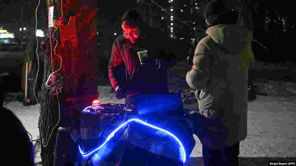 DJ na uličnoj zabavi kojoj su prisustvovali stanovnici Kijeva pogođeni nestancima električne energije.