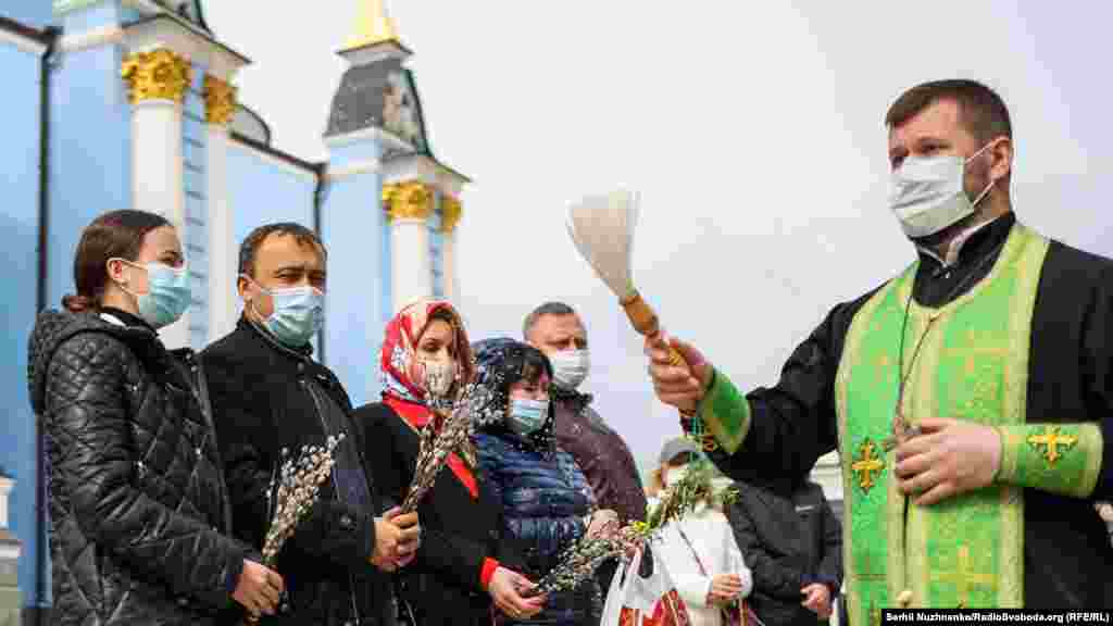 Священники окроплюють святою водою вірян та вербу в кафедральному Михайлівському соборі Свято-Михайлівського Золотоверхого монастиря, що належить Православній церкві України