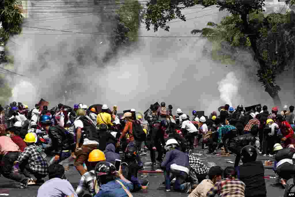 Protesters react after police fired tear gas during a demonstration against the military coup in Mandalay on March 3, 2021.