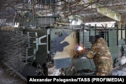 A Russian armored vehicle is fitted with anti-drone armor in Russian-held territory in Ukraine’s Zaporizhzhya region.