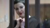 Maryya Kalesnikava forms a heart shape to supporters from inside a defendants' cage at her trial in Minsk on September 6.