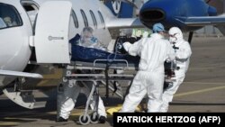 Francia orvosok egy Lyonból érkező koronavírusos beteget szállítanak kórházba Strasbourg repteréről, 2020.11.06.