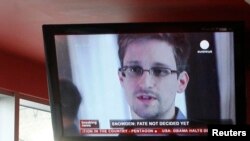 Russia -- A television screen shows former US spy agency contractor Edward Snowden during a news bulletin at a cafe at Moscow's Sheremetyevo airport, July 24, 2013