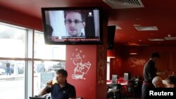 A television shows former U.S. intelligence contractor Edward Snowden during a news bulletin at a cafe at Moscow's Sheremetyevo Airport.