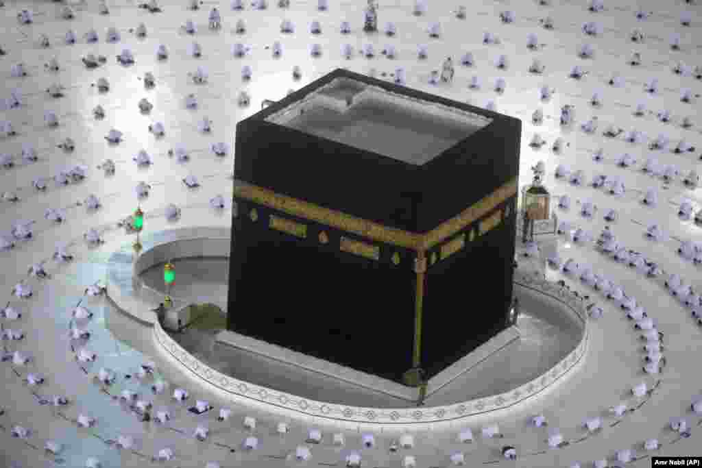 Мекка, Саудовская Аравия. Мусульмане проводят молитву на рассвете перед началом Рамадана у Каабы &ndash; исламской святыни во внутреннем дворе Заповедной мечети в Мекке. Верующие соблюдают социальную дистанцию, чтобы предотвратить распространение коронавируса&nbsp;