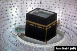 ARABIA SAUDITĂ - Musulmanii se roagă în timpul primelor rugăciuni din zori, în luna sfântă islamică a Ramadanului, în jurul Kaaba, clădirea cubică de la Marea Moschee, cu păstrarea distanțării sociale pentru a limita răspândirea coronavirusului.