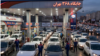 Iranians line up in their vehicles to get gas at a station in Tehran. 