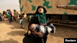 A woman fleeing fighting between Islamic State militants and Iraqi forces in eastern Mosul reacts as she heads to safer territory on November 8.