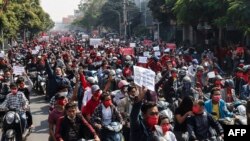 MYANMAR -- Protesters hold posters during a demonstration against the military coup near the royal palace in Mandalay on February 7, 2021.