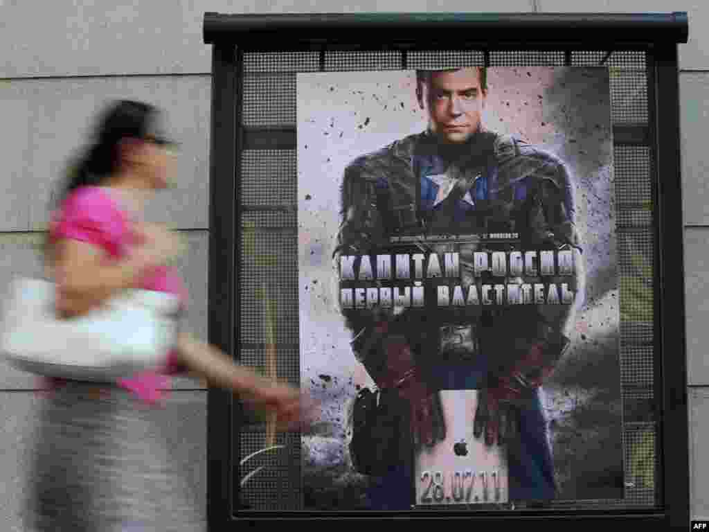 A woman passes a mysterious poster depicting Russian President Dmitry Medvedev in a "Captain America" costume with the words "Captain Russia , the first Lord" in central Moscow on July 26. Photo by Natalia Kolesnikova for AFP