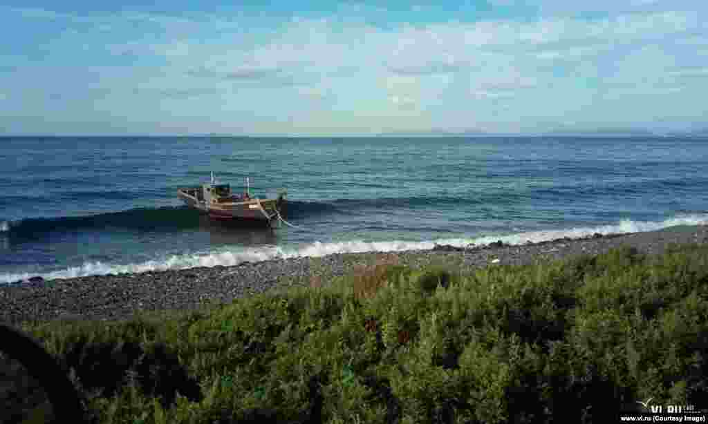 A fishing boat rolling in the waves after it drifted to shore near the town of Zarubino on August 30.