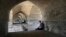 In this Tuesday, July 10, 2018 photo, people rest under an arch of the 400-year-old Si-o-seh Pol bridge, named for its 33 arches, that now spans a dried up Zayandeh Roud river, in Isfahan, Iran.