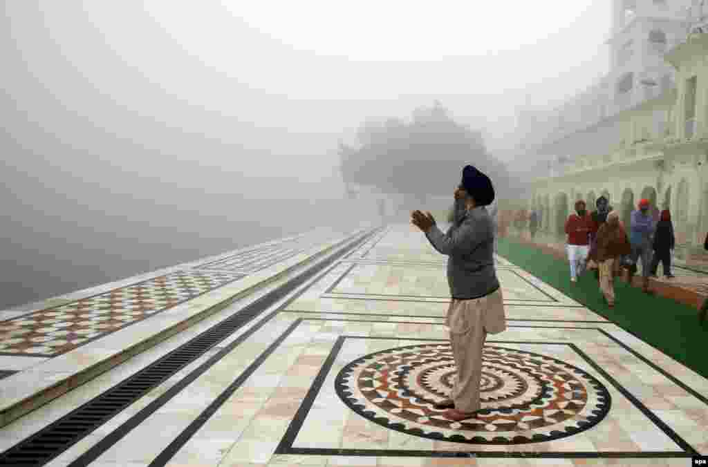 A Sikh man prays at the Golden Temple, the holiest of Sikh shrines, on a dense foggy morning in Amritsar, India. (epa/Raminder Pal Singh)