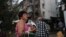Жінка тримає свого собаку, разом з яким покинула пошкоджений російською атакою будинок