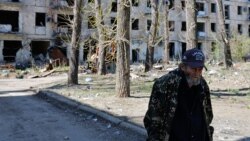 Илустрација - Жител на Авдивијка пред уништена станбена зграда