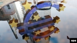 Odraz znaka eura postavljenog ispred Evropske centralne banke u Frankfurtu