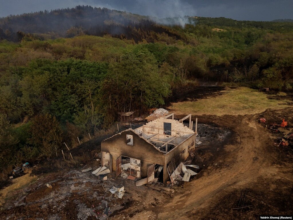Një pamje nga droni që shfaq një fermë të djegur nga një zjarr i egër në fshatin Lubizhde, në Kosovë, më 26 korrik.