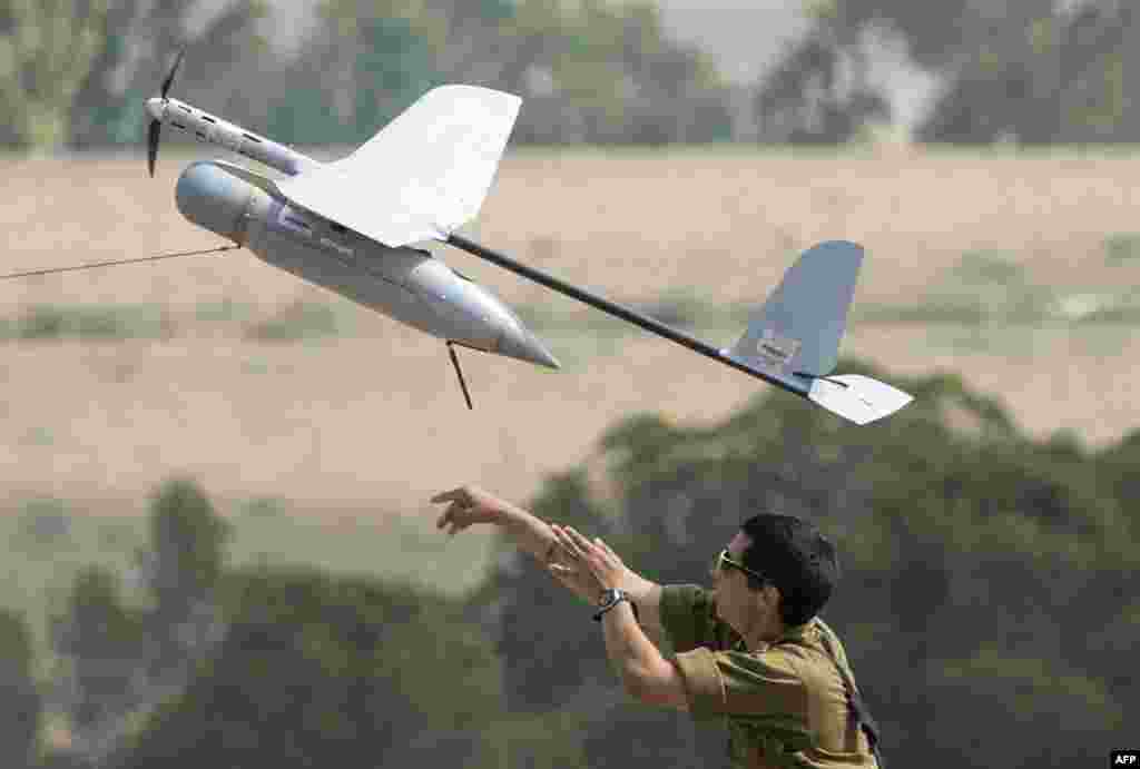 An Israel soldier launches a Skylark I unmanned drone aircraft, which is used for monitoring purposes, at an army deployment area near Israel&#39;s border with the besieged Palestinian territory of Gaza on July 23. (AFP/Jack Guez)