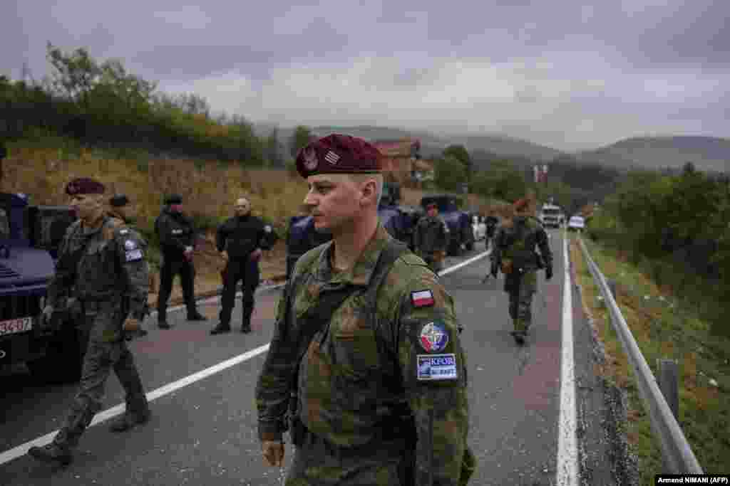 Primul ministru albanez, Edi Rama, a vizitat Kosovo pe 27 septembrie și a criticat &bdquo;manevrele militare teatrale&rdquo; ale Serbiei, spunând că &bdquo;singura soluție este dialogul&rdquo;. În fotografie, soldați NATO trec pe lângă Unitatea de Operațiune Specială a Poliției din Kosovo, în misiunea de patrulare de la granița dintre Kosovo și Serbia, la Jarinje, 28 septembrie 2021.