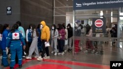 Lucrătorii Crucii Roșii primind la aeroportul din Bogota (Columbia) migranți deportați din SUA, la 28 ianuarie.