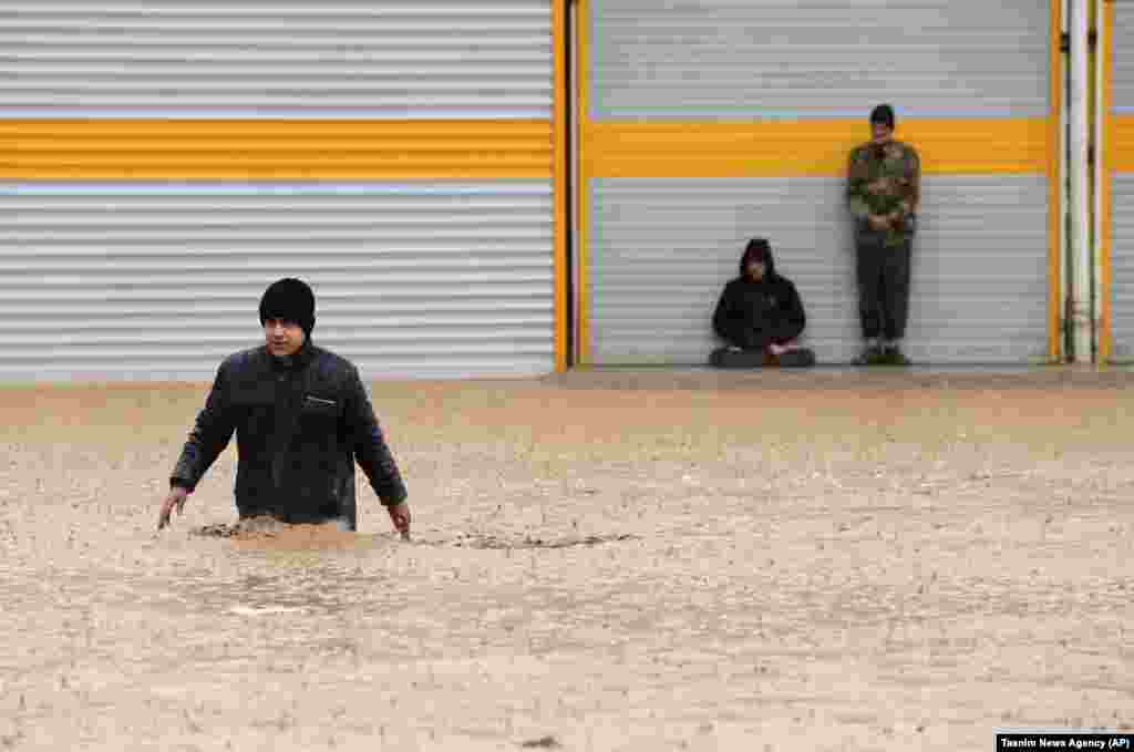 A man crosses a flooded street in the city of Khorramabad in the western Iranian province of Lorestan. (AP/Saeed Soroush)