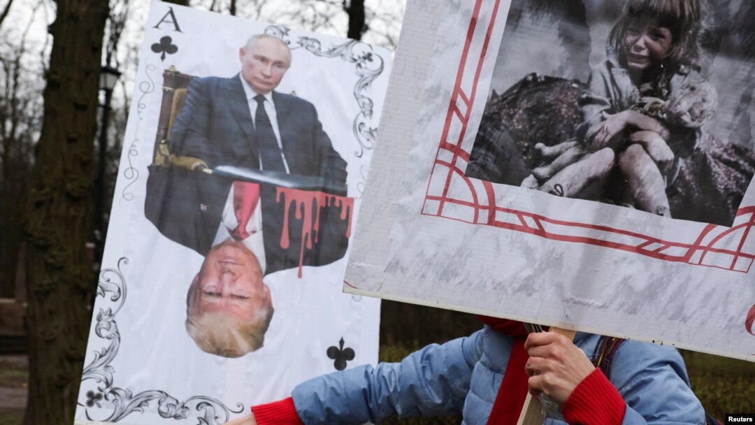 A demonstrator holds signs during a protest outside the US Embassy in Kyiv on March 15. 