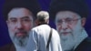 A man walks past a billboard depicting Iran's late Supreme Leader Ayatollah Ali Khamenei (right) and his son and successor, Mojtaba Khamenei, on a street in Tehran on April 15.