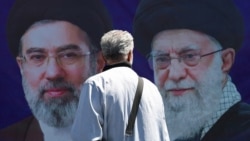 A man walks past a billboard depicting Iran's late Supreme Leader Ayatollah Ali Khamenei (right) and his son and successor, Mojtaba Khamenei, on a street in Tehran on April 15.