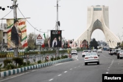 Изображения убитого в результате воздушного удара США и Израиля Высшего руководителя Ирана, великого аятоллы Али Хаменеи на одной из автотрасс в Тегеране. 23 марта 2026 года